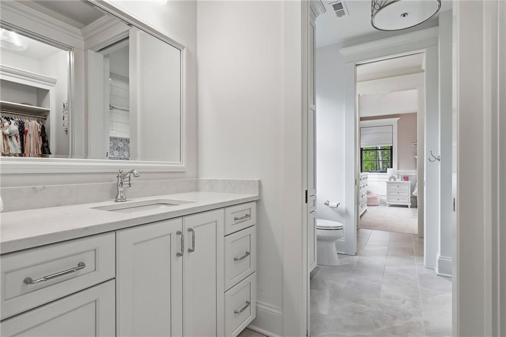 225 Stoup Road Mars, PA 16046 - Photo 36 of 50 The jack-and-jill bathroom features individual vanities with quartz countertops, framed mirrors, chrome fixtures, and ceramic tile flooring — with pocket doors providing private access from each bedroom and a dedicated walk-in closet visible for each room.