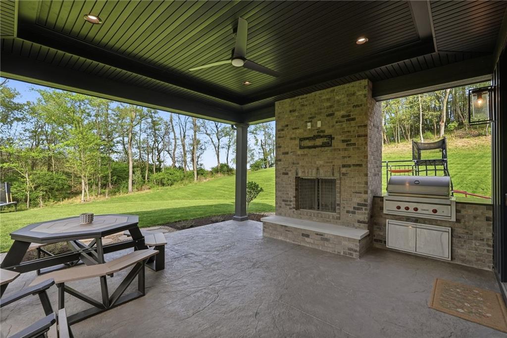 225 Stoup Road Mars, PA 16046 - Photo 43 of 50 The covered stamped concrete patio features a gas-assist brick fireplace, built-in Wolf gas grill, tongue and groove ceiling with recessed lighting and a ceiling fan, all looking out over the manicured lawn and wooded surroundings of 6.45 private acres. The home is already plumbed for a future pool, making this outdoor space as ready for the future as it is to enjoy today.