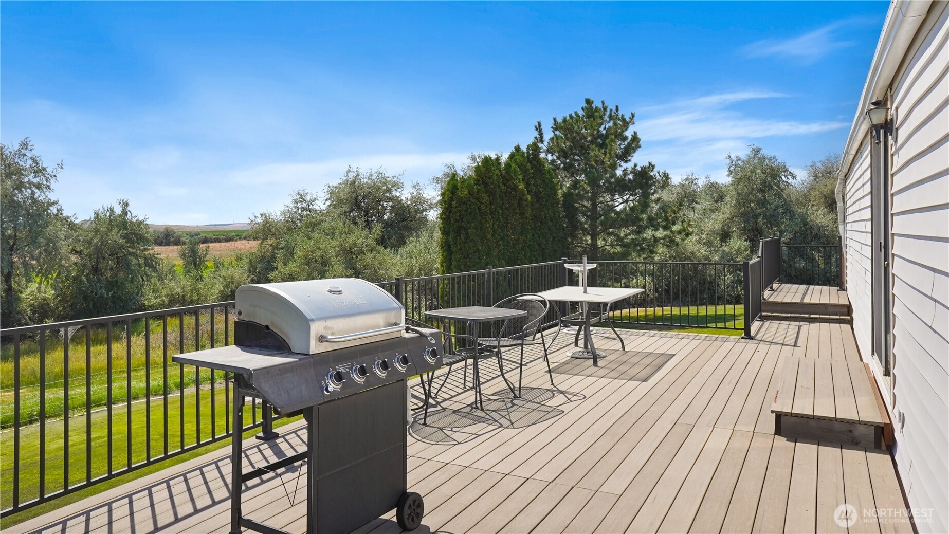 101 Mail Road Othello, WA 99344 - Photo 4 of 40 a view of a roof deck with table and chairs a barbeque with wooden floor and fence