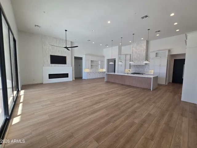 a view of a kitchen with kitchen island a window wooden floor and a refrigerator
