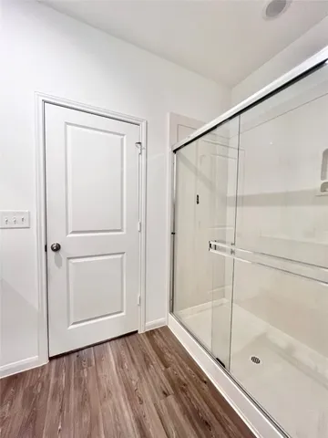 a bathroom with a shower and a glass door