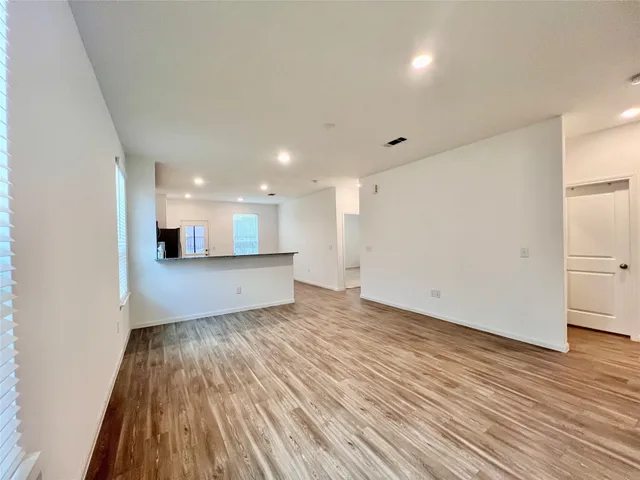 a view of a big room with wooden floor and windows