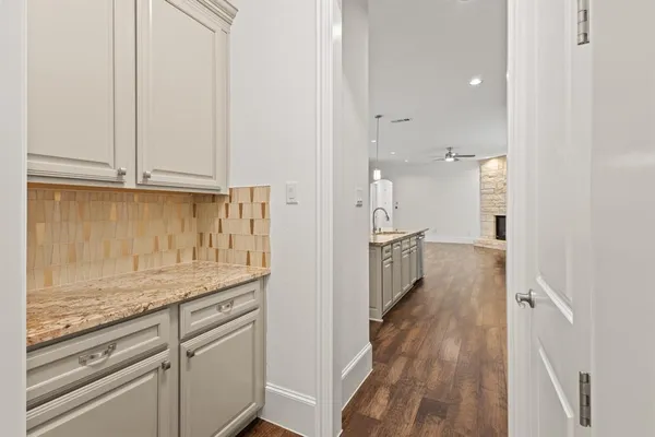 a view of a kitchen with granite countertop white cabinets and stainless steel appliances