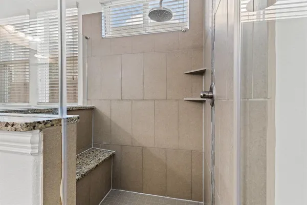 a bathroom with a granite countertop sink a vanity and window