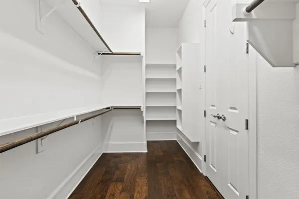 a view of a hallway with wooden floor and entryway