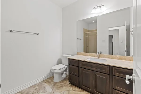 a bathroom with a granite countertop sink a toilet and a mirror