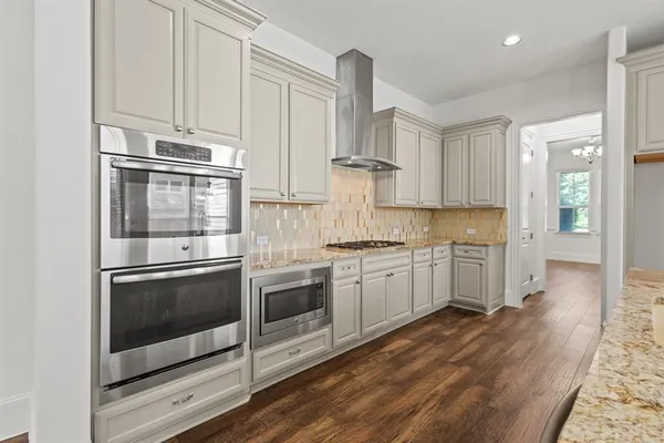 a kitchen with stainless steel appliances granite countertop a stove a sink and a refrigerator