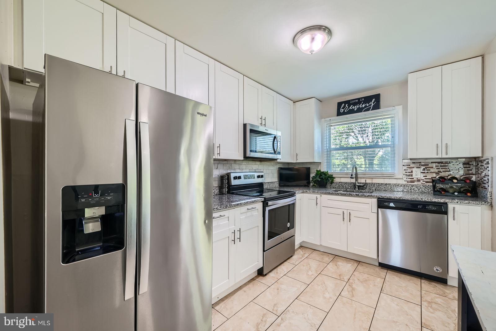1201 Cobb Road Baltimore, MD 21208 - Photo 11 of 28 a kitchen with granite countertop a refrigerator stove top oven and sink
