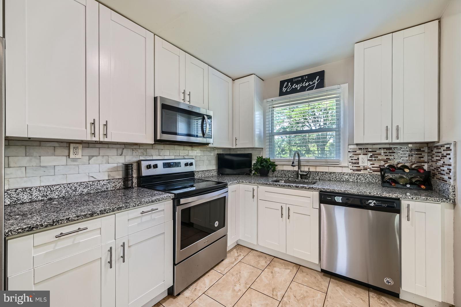 1201 Cobb Road Baltimore, MD 21208 - Photo 12 of 28 a kitchen with stainless steel appliances granite countertop white cabinets granite counter tops and a window