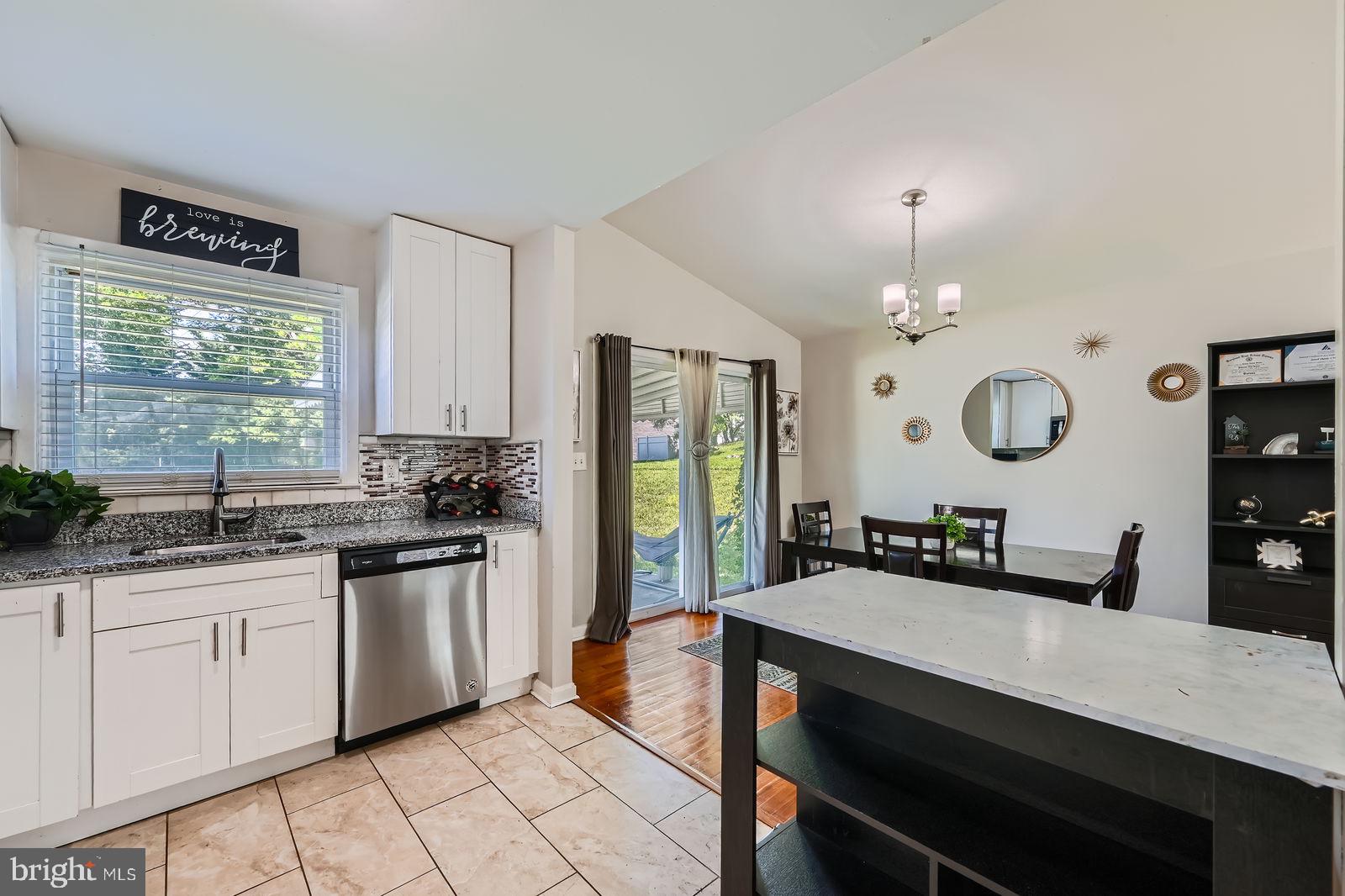 1201 Cobb Road Baltimore, MD 21208 - Photo 13 of 28 a kitchen with granite countertop a sink a stove cabinets and living room view