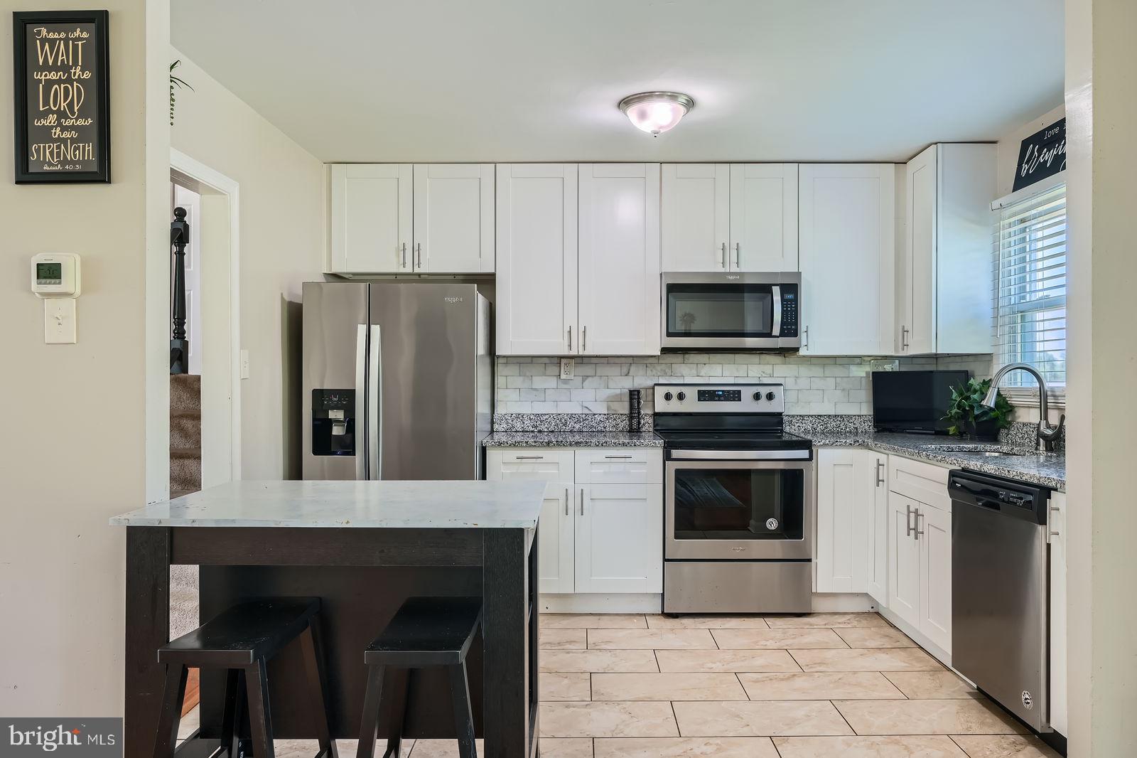 1201 Cobb Road Baltimore, MD 21208 - Photo 14 of 28 a kitchen with cabinets a microwave and refrigerator