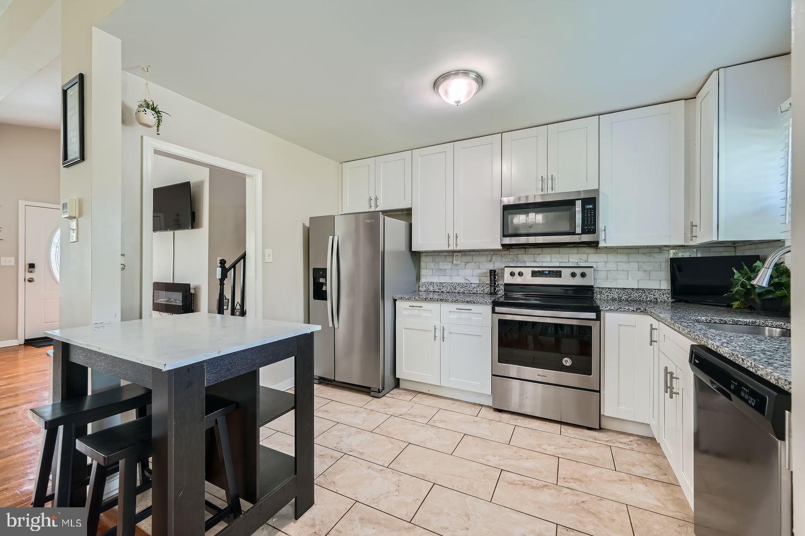 1201 Cobb Road Baltimore, MD 21208 - Photo 9 of 28 a kitchen with stainless steel appliances a stove a sink refrigerator and a microwave