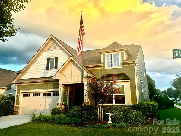 a front view of a house with a yard and potted plants