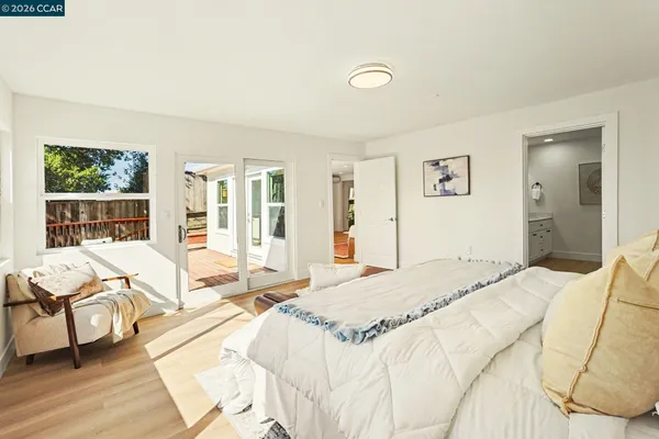 a spacious bedroom with a bed and glass windows