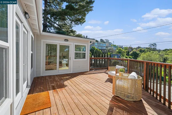 a view of a patio with couches chairs and wooden floor