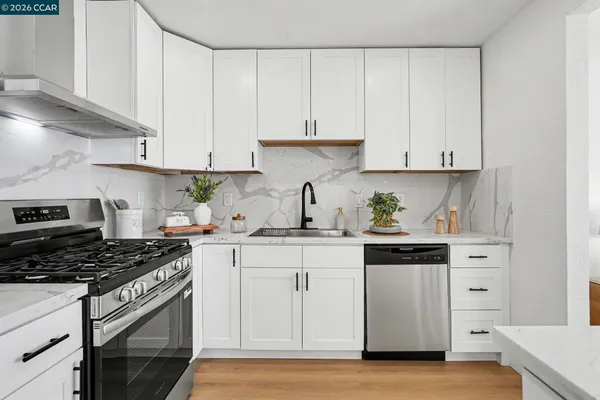 a kitchen with granite countertop white cabinets and white appliances