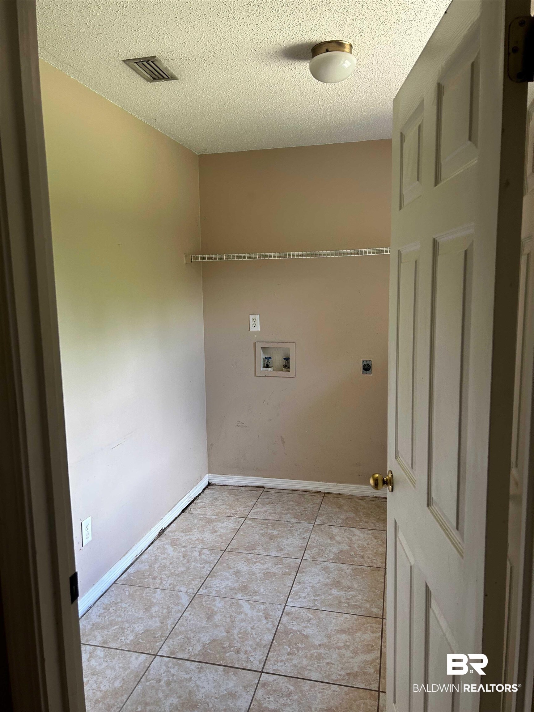 15602 Wrangler Road Summerdale, AL 36580 - Photo 11 of 14 Washroom with washer hookup, light tile patterned floors, a textured ceiling, and hookup for an electric dryer