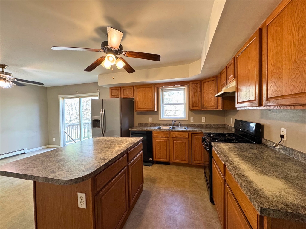 3 Davids Way, Unit A Wareham, MA 02576 - Photo 10 of 18 a kitchen with granite countertop kitchen island a stove a sink a refrigerator dining table and chairs