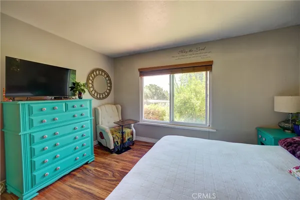 a bedroom with furniture and a flat screen tv