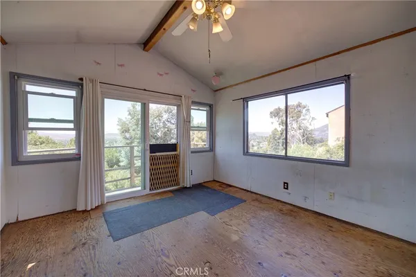 an empty room with windows and ceiling fan