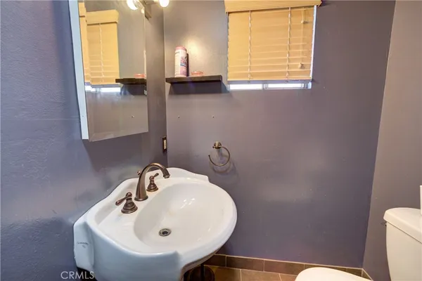 a bathroom with a sink a toilet and a mirror