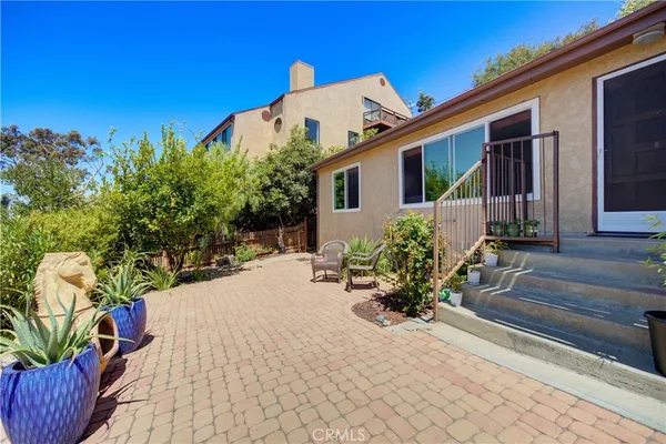a view of a house with chairs and potted plants