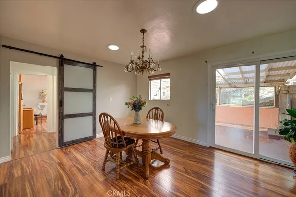 a dining room with furniture a chandelier and wooden floor