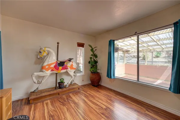 a room with wooden floor and large windows