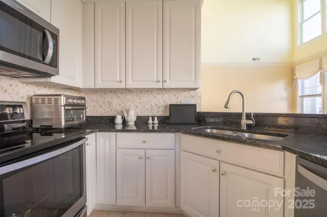 a kitchen with white cabinets and refrigerator