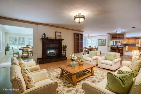 a living room with furniture kitchen view and a fireplace