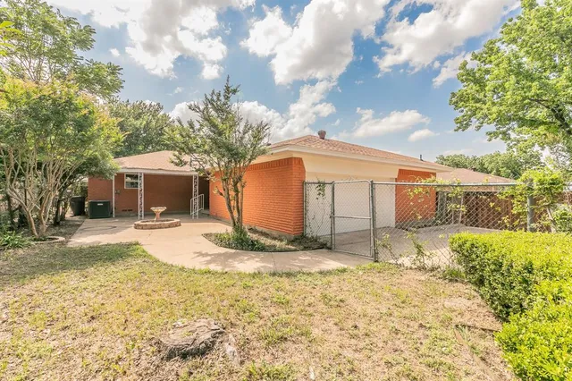 a view of a house with snow on the ground and large trees