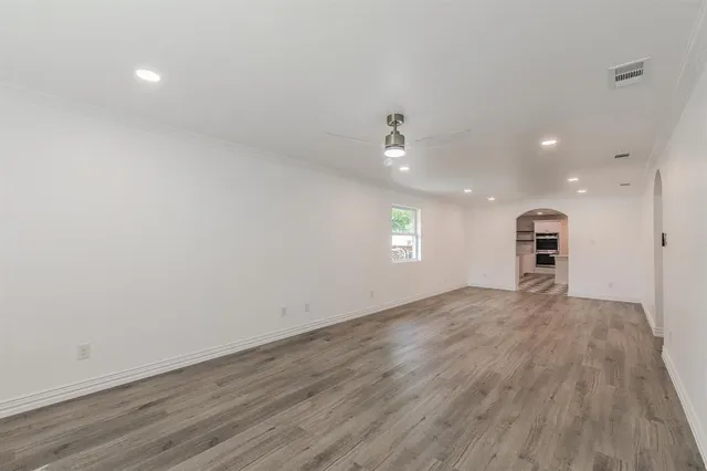 a view of empty room with wooden floor