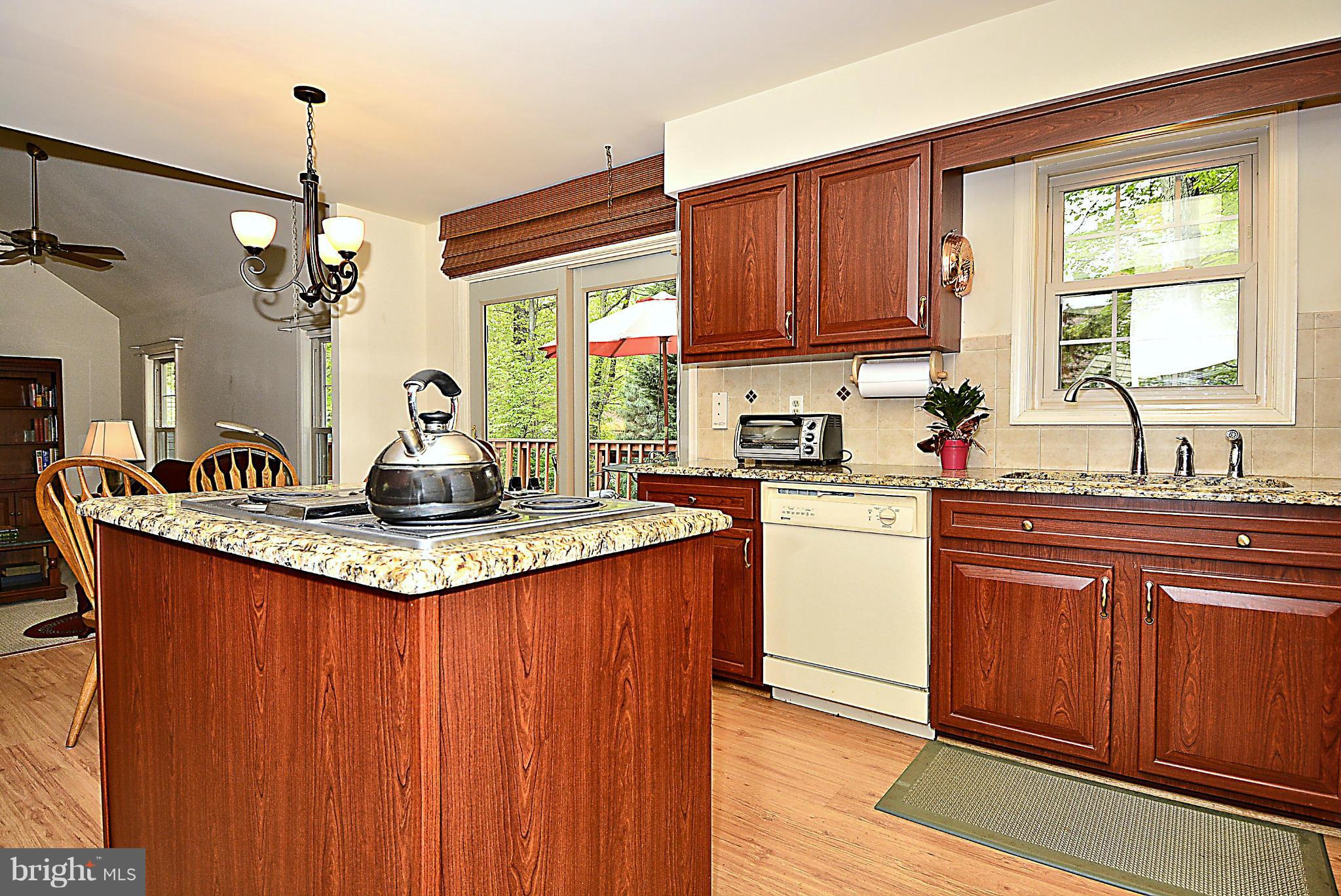 9213 Wyeth Lane Burke, VA 22015 - Photo 5 of 28 a kitchen with kitchen island granite countertop a sink stainless steel appliances and cabinets