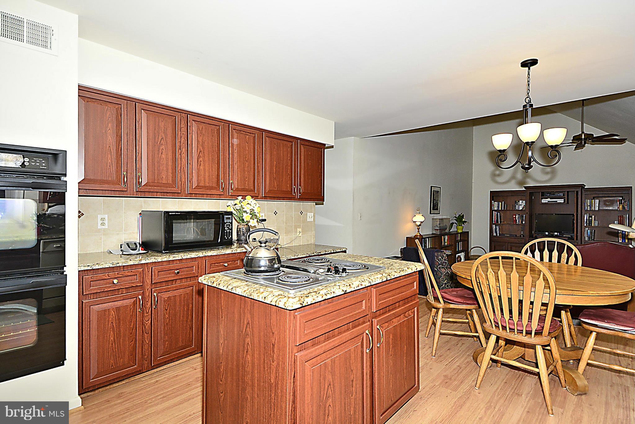 9213 Wyeth Lane Burke, VA 22015 - Photo 7 of 28 a kitchen with stainless steel appliances granite countertop a stove top oven a sink dishwasher and cabinets with wooden floor