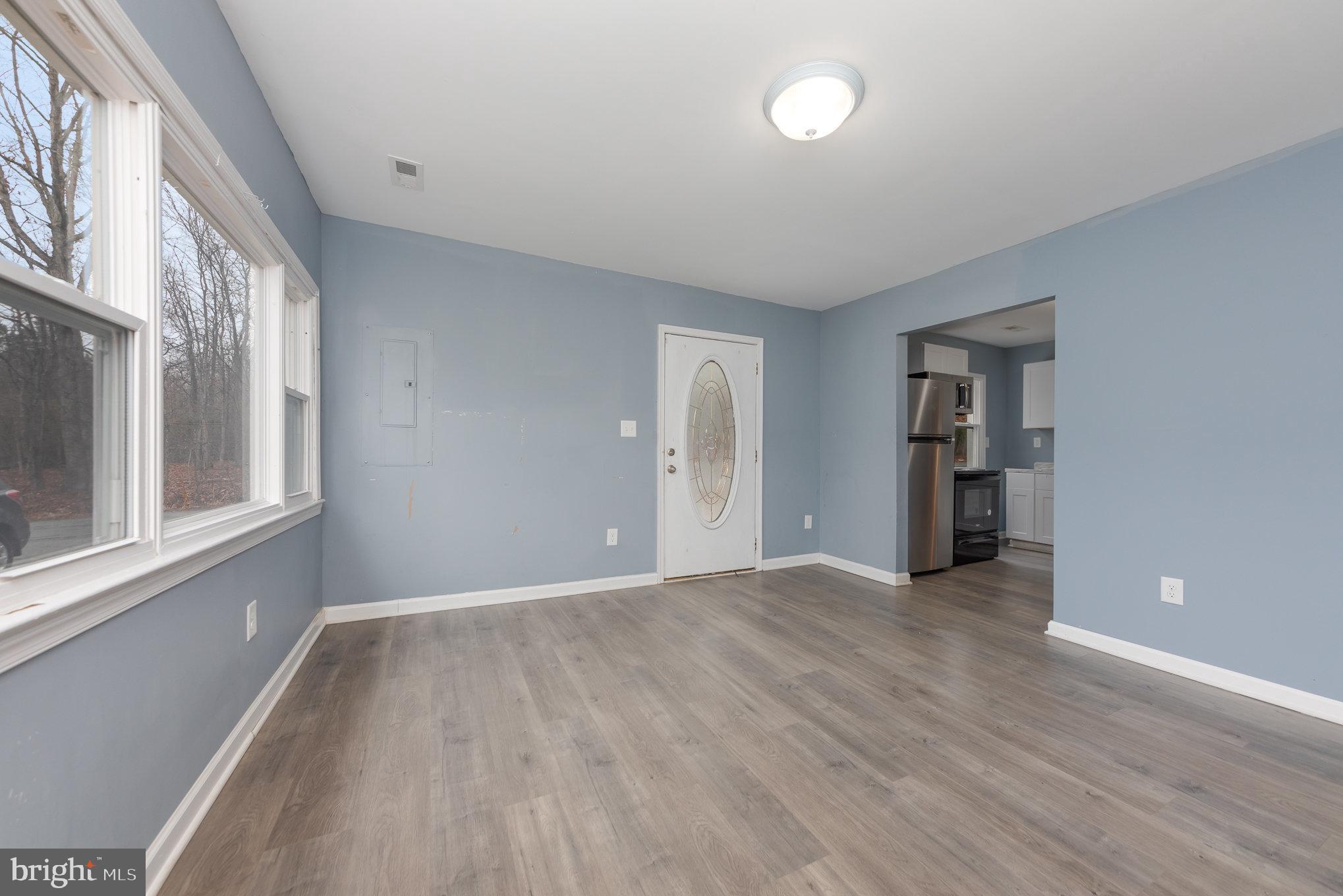 9003 Smiths Bend Road Fredericksburg, VA 22407 - Photo 4 of 22 a view of an empty room with wooden floor and a window