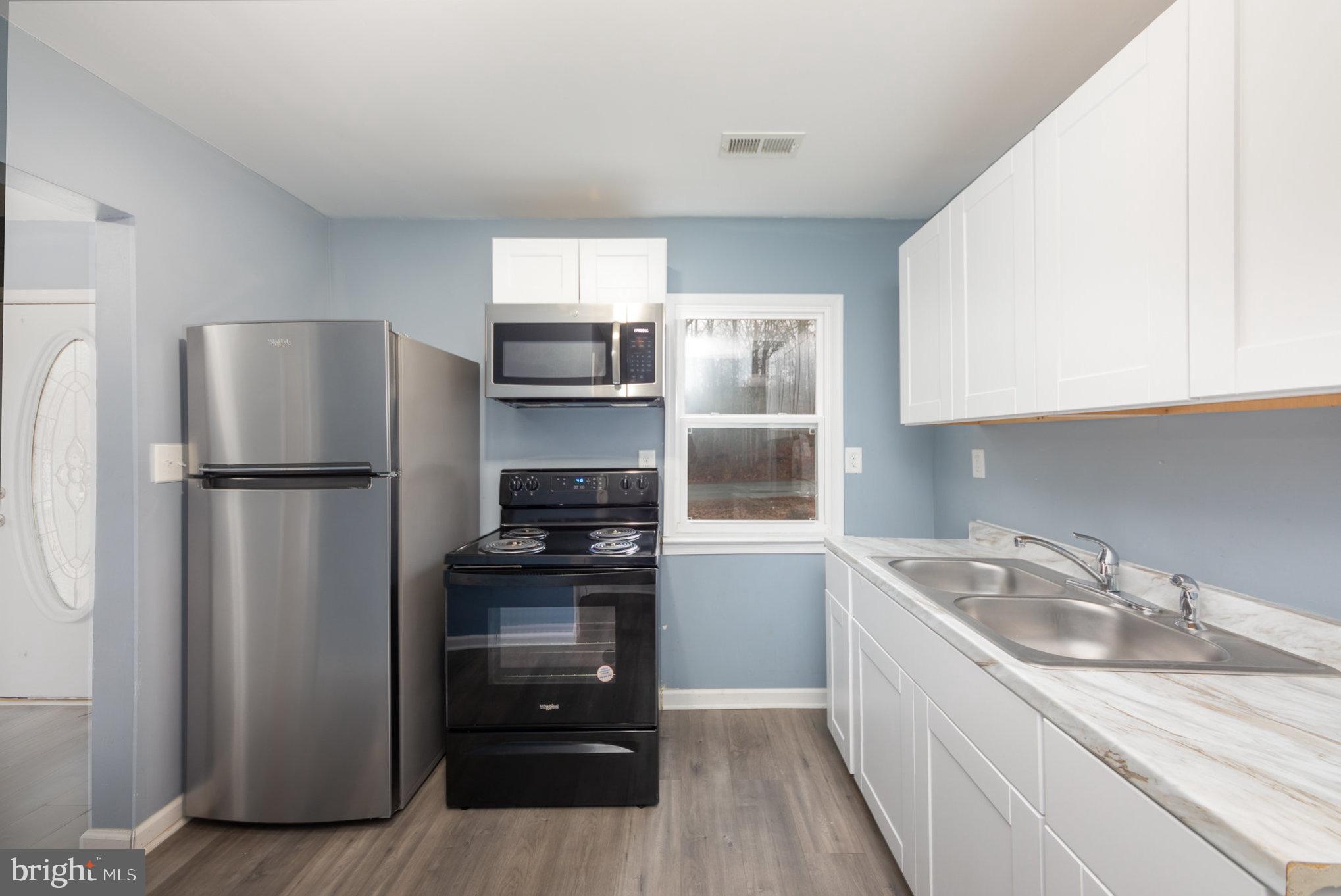 9003 Smiths Bend Road Fredericksburg, VA 22407 - Photo 6 of 22 a kitchen with a refrigerator and a sink