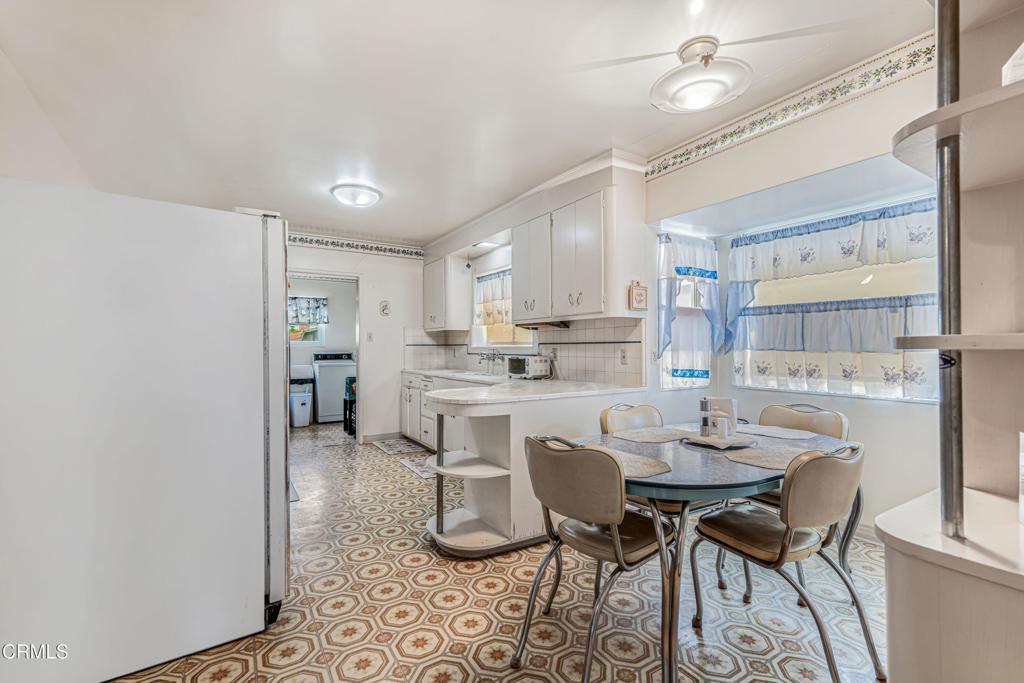 336 Doris Avenue Oxnard, CA 93030 - Photo 15 of 44 a kitchen with a dining table chairs refrigerator and cabinets