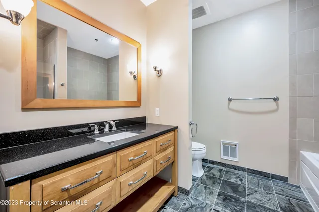 a bathroom with a toilet a sink and mirror