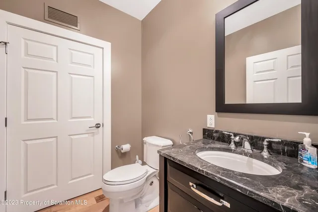 a bathroom with a sink a toilet and mirror