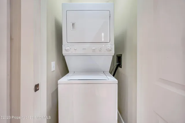 a view of a hallway with wooden floor and a bathroom