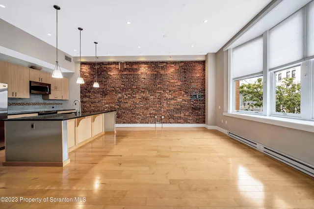 a kitchen with stainless steel appliances granite countertop a sink a oven a refrigerator cabinets and a dining table