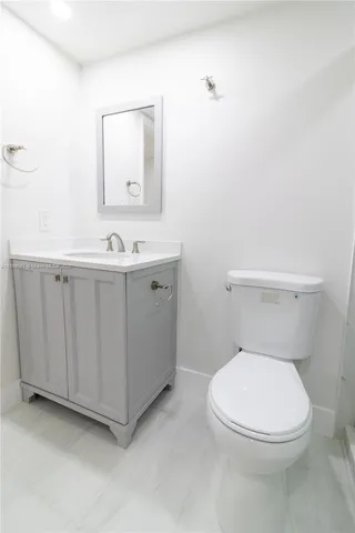 a white toilet sitting next to a bathroom sink