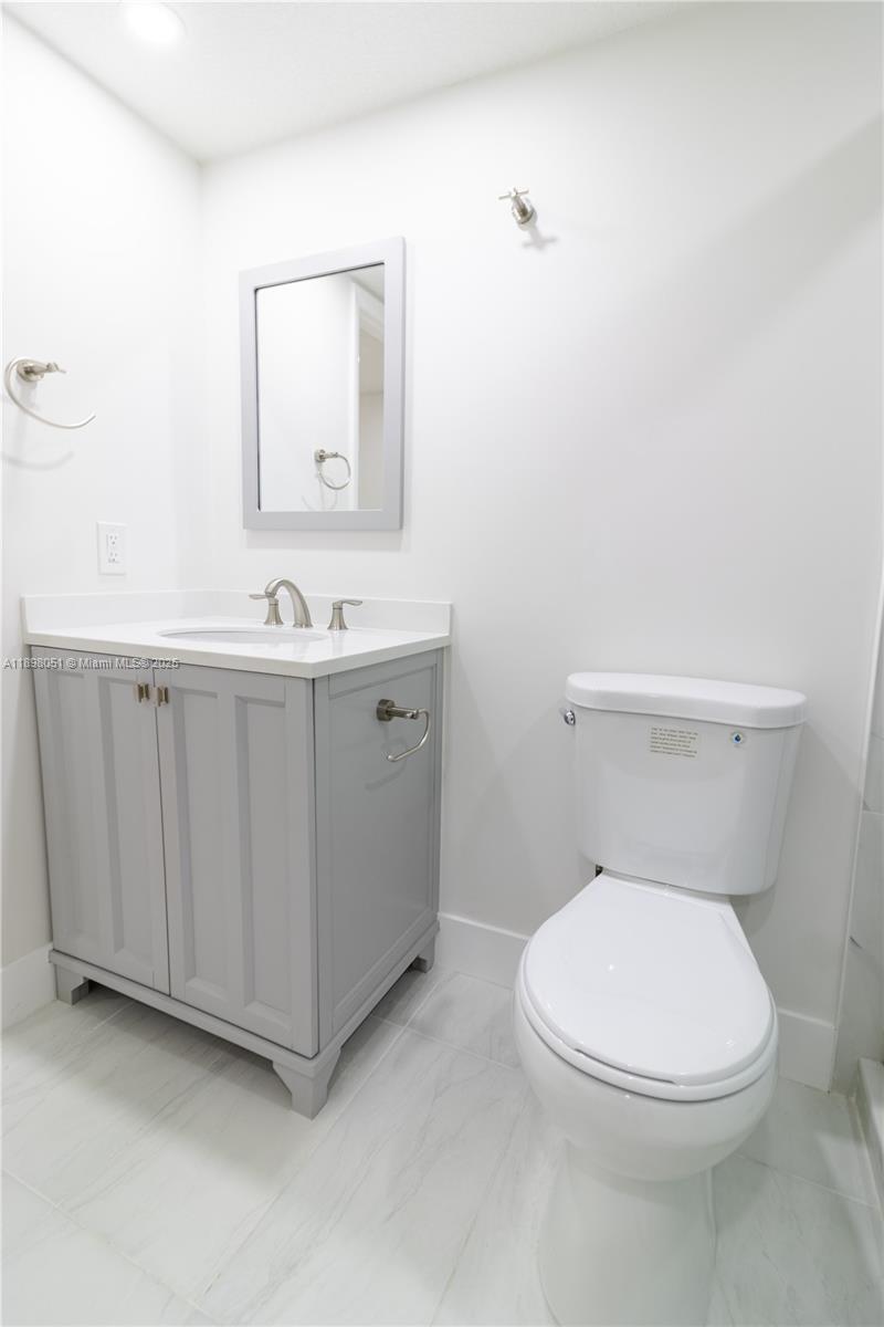 217 Northwest 109th Avenue, Unit 2217 Miami, FL 33172 - Photo 14 of 19 a white toilet sitting next to a bathroom sink