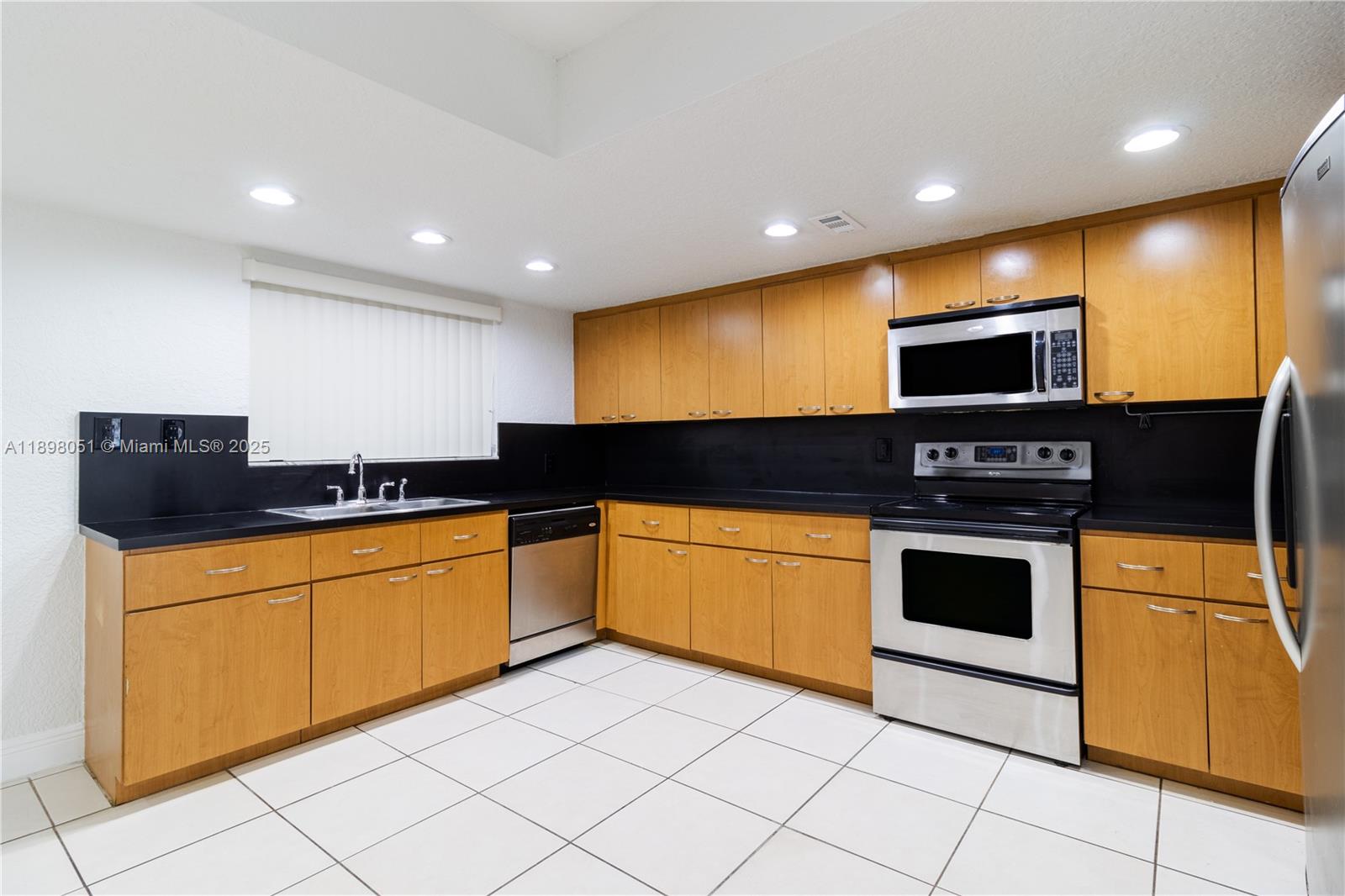 217 Northwest 109th Avenue, Unit 2217 Miami, FL 33172 - Photo 5 of 19 a kitchen with stainless steel appliances granite countertop a stove a sink and a microwave