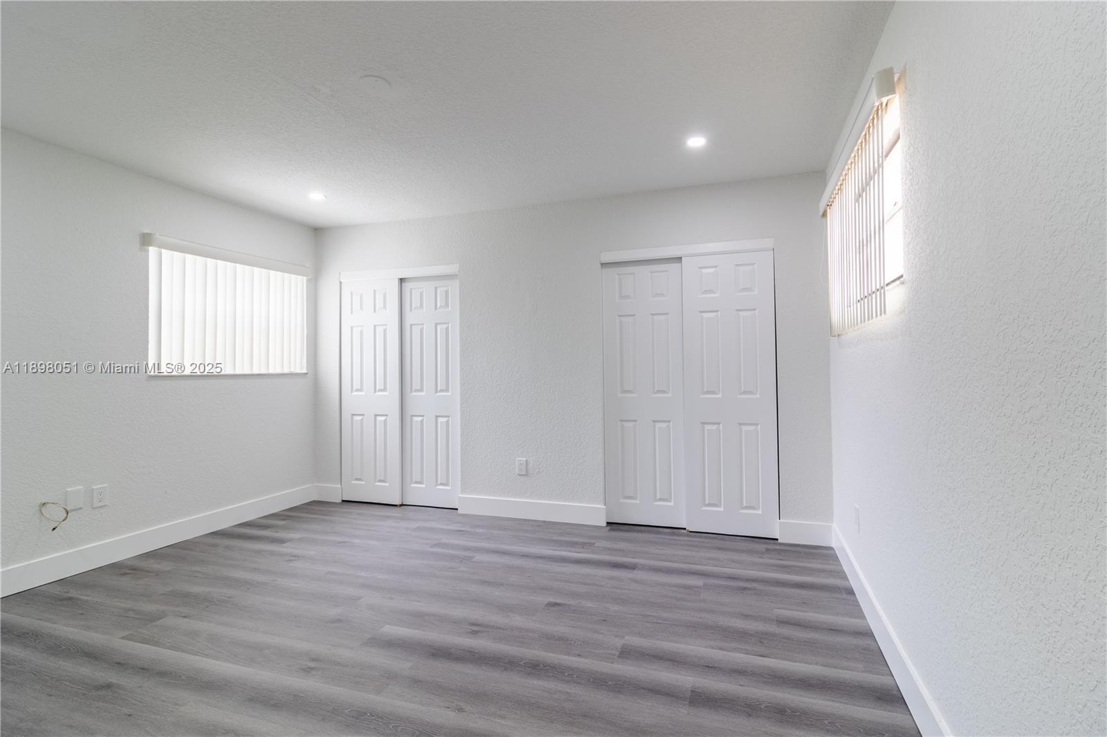 217 Northwest 109th Avenue, Unit 2217 Miami, FL 33172 - Photo 10 of 19 an empty room with wooden floor and windows