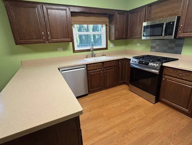 a kitchen with stainless steel appliances a refrigerator stove microwave and sink