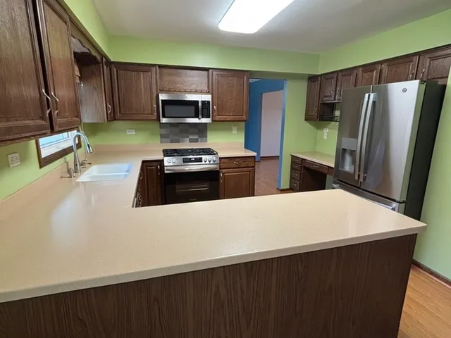 a kitchen with stainless steel appliances granite countertop a sink stove and refrigerator
