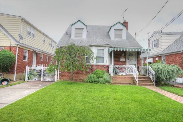 a front view of a house with a yard and potted plants