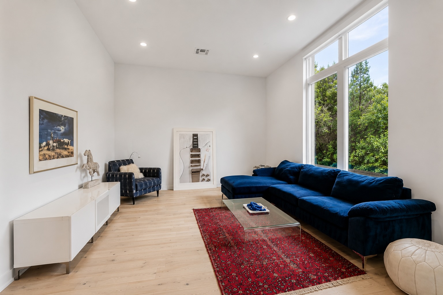 2520 Sutherland Street Austin, TX 78746 - Photo 10 of 26 Natural light pours into this bright living area, highlighting high ceilings and light wood floors.