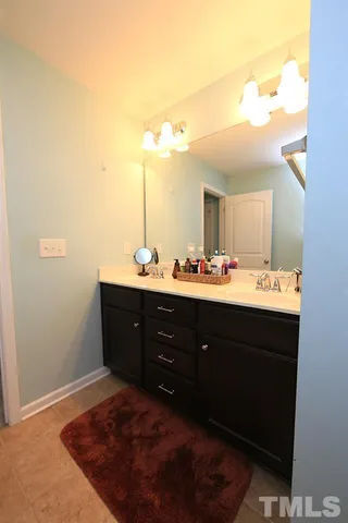 a bathroom with a sink vanity and mirror
